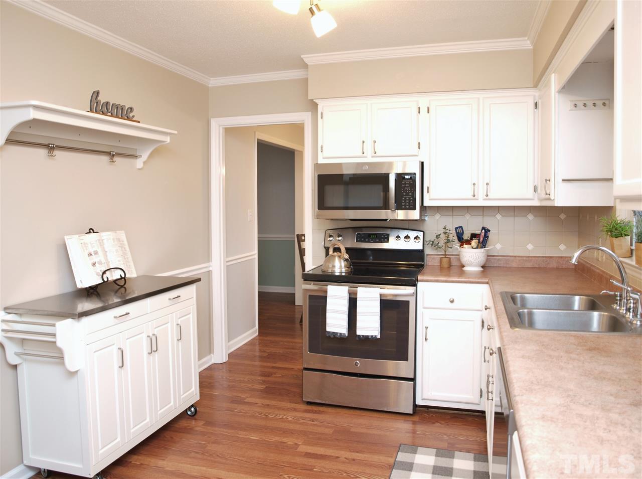 1117 Toppe Ridge Court Raleigh, NC 27615 - Photo 5 of 30 a kitchen with stainless steel appliances a stove microwave and sink