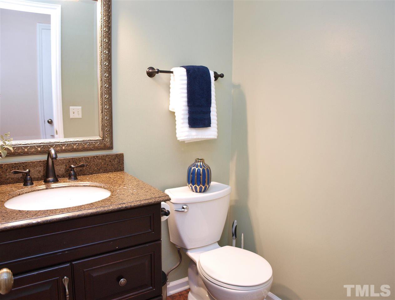 1117 Toppe Ridge Court Raleigh, NC 27615 - Photo 6 of 30 a bathroom with a granite countertop toilet sink mirror and vanity