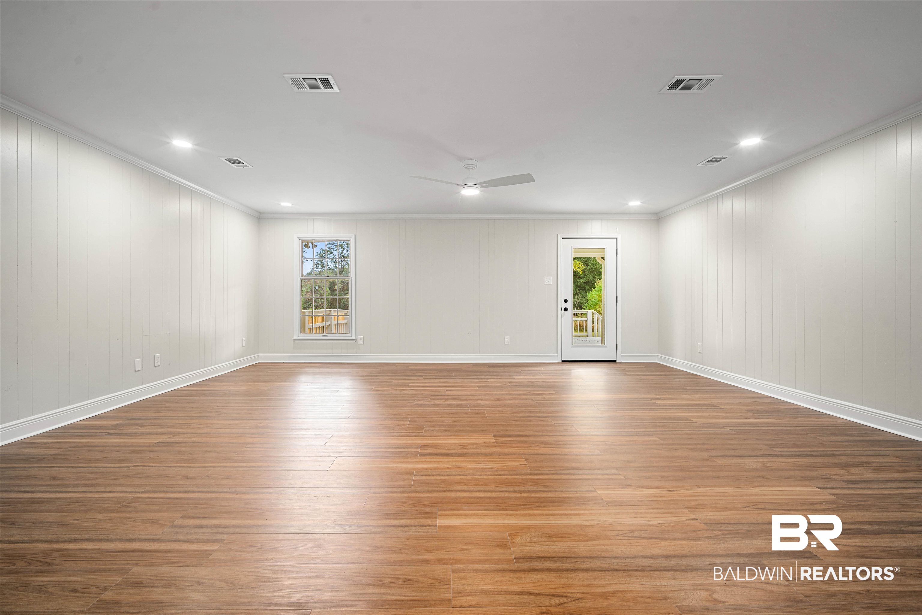 3050 Lacoste Road Mobile, AL 36618 - Photo 6 of 30 Unfurnished room with ornamental molding, wood finished floors, recessed lighting, wooden walls, and a ceiling fan