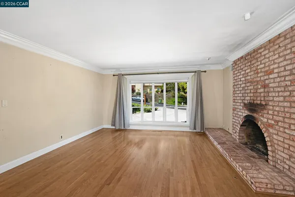 wooden floor fireplace and windows in an empty room