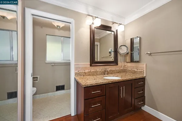 a bathroom with a granite countertop sink and a mirror