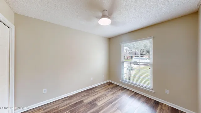 an empty room with wooden floor and windows