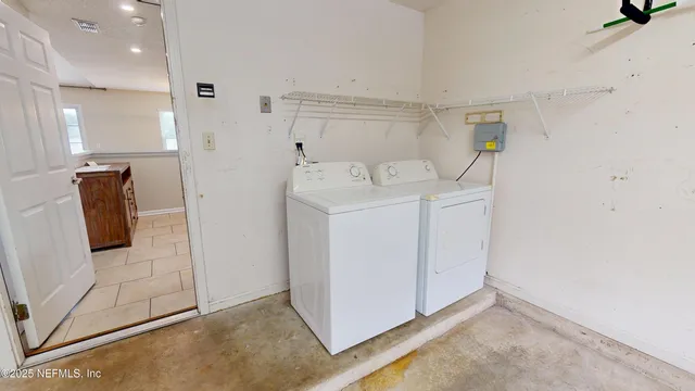 a utility room with cabinets washer and dryer