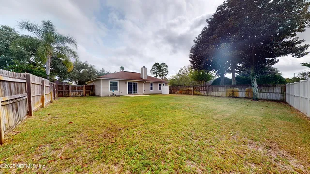 a front view of house with yard and trees in the background