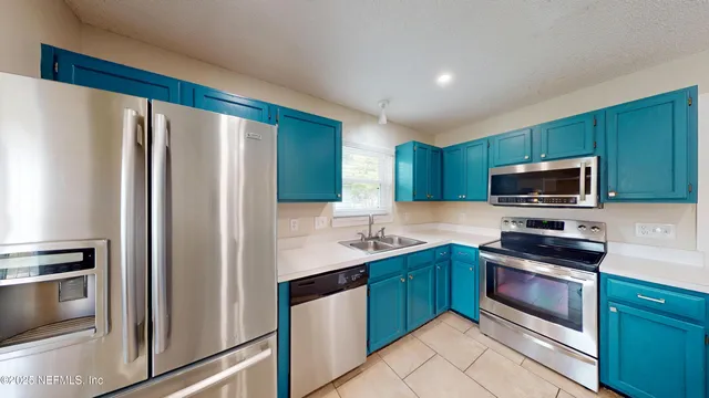 a kitchen with stainless steel appliances a refrigerator stove and microwave