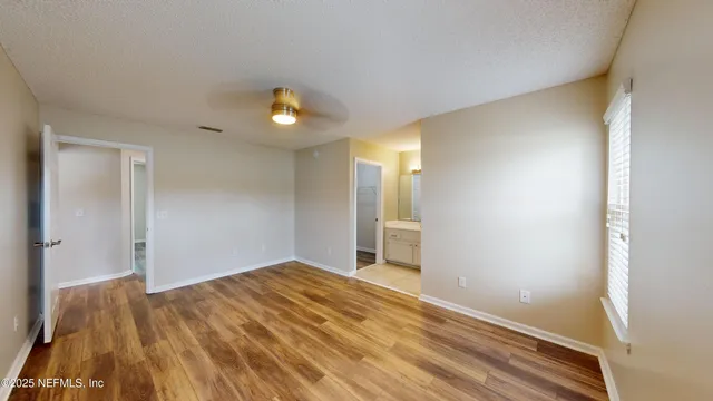 a view of a big room with wooden floor and windows
