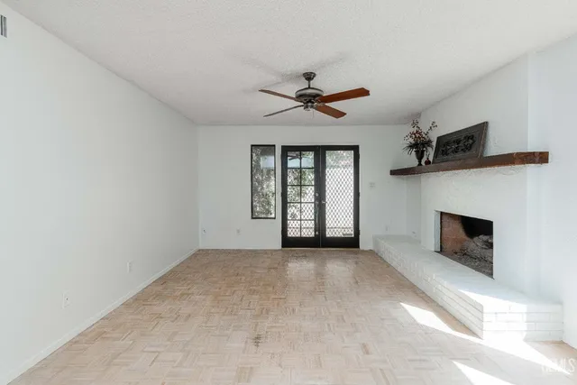 a view of empty room with fireplace and fan