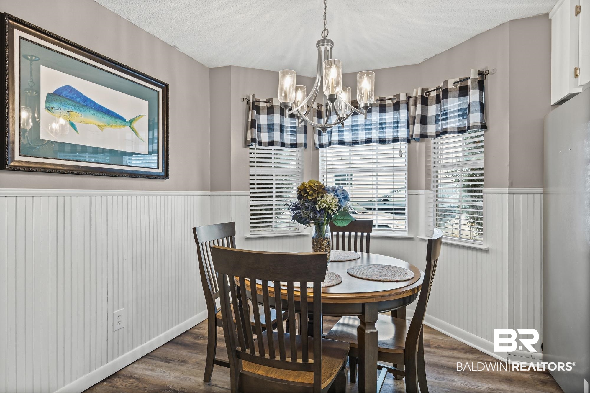 6609 Blakeley Court Mobile, AL 36695 - Photo 7 of 28 Dining room with dark wood finished floors, a chandelier, wainscoting, and a textured ceiling