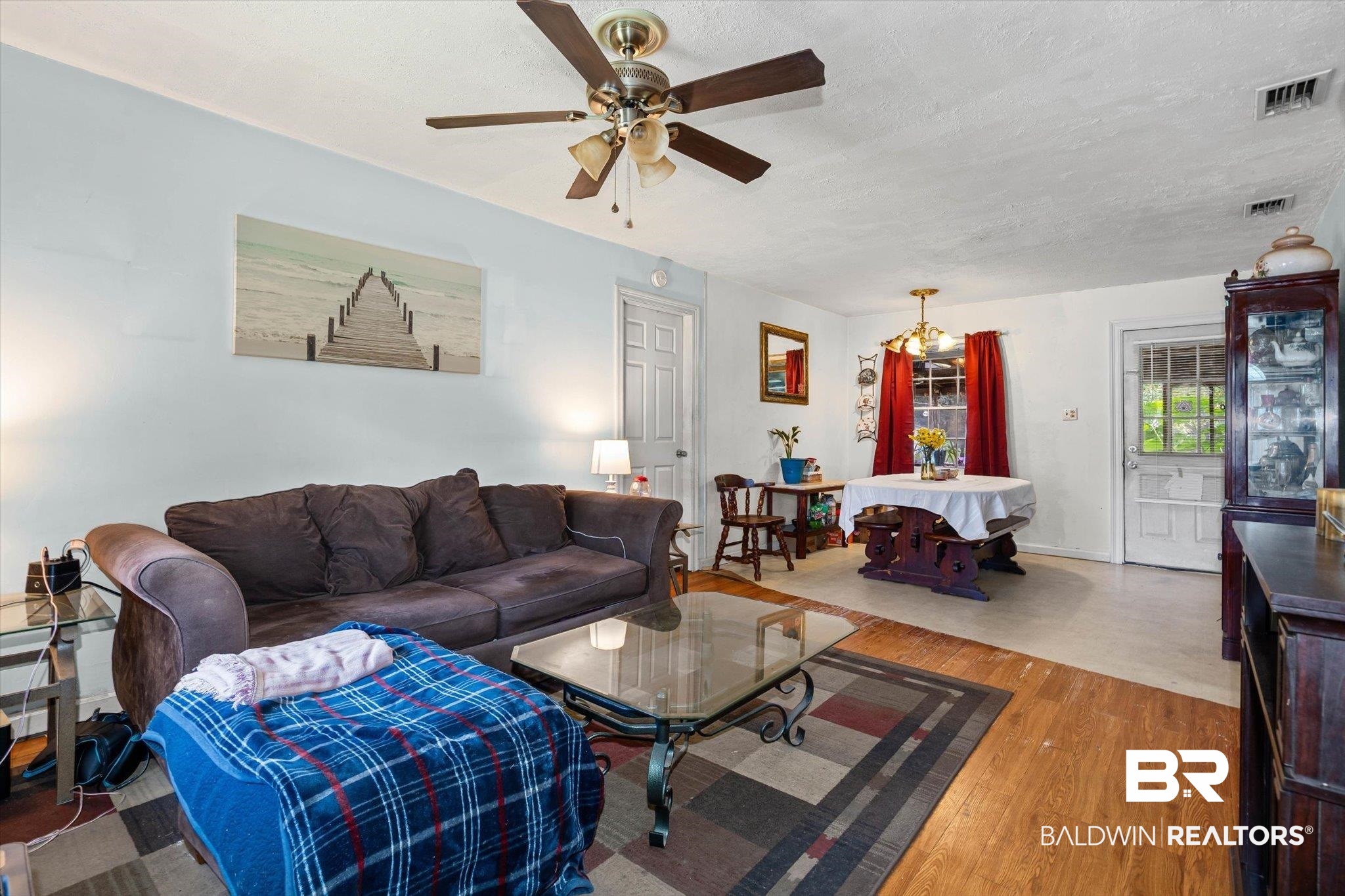 7991 Three Notch Road Theodore, AL 36582 - Photo 3 of 22 Living area with wood finished floors, a ceiling fan, and a textured ceiling