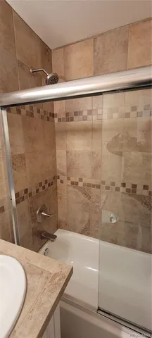 a bathroom with a granite countertop sink mirror and a bathtub