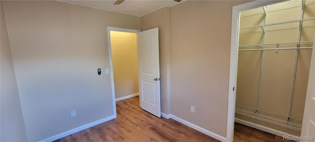an empty room with wooden floor and entrance