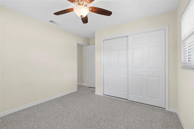 an empty room with closet and windows