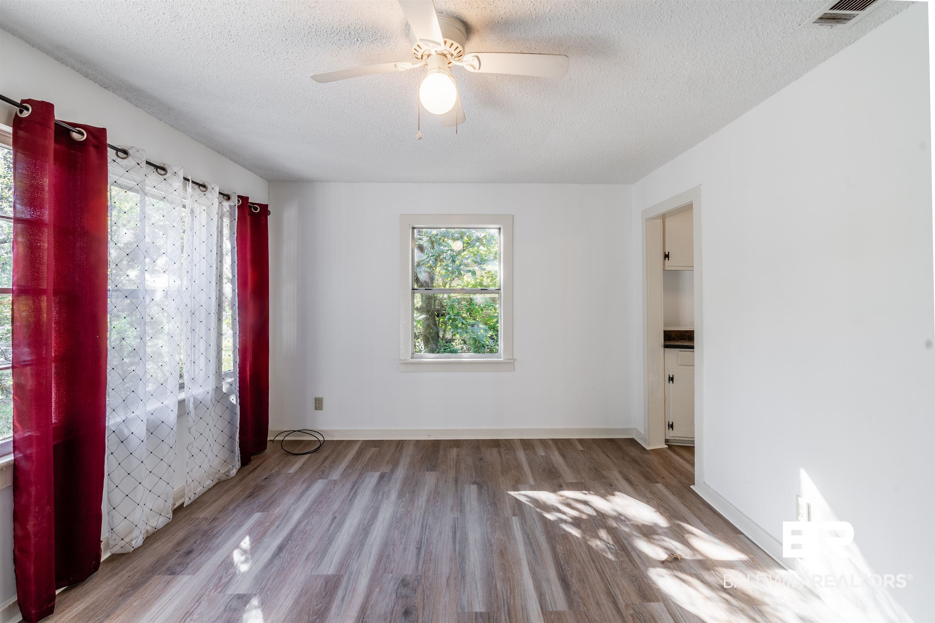 3900 Brookmont Drive Mobile, AL 36605 - Photo 3 of 19 Unfurnished room with ceiling fan, hardwood / wood-style floors, and a textured ceiling