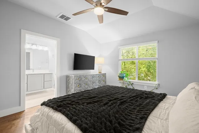 a bedroom with a bed window and a flat tv screen
