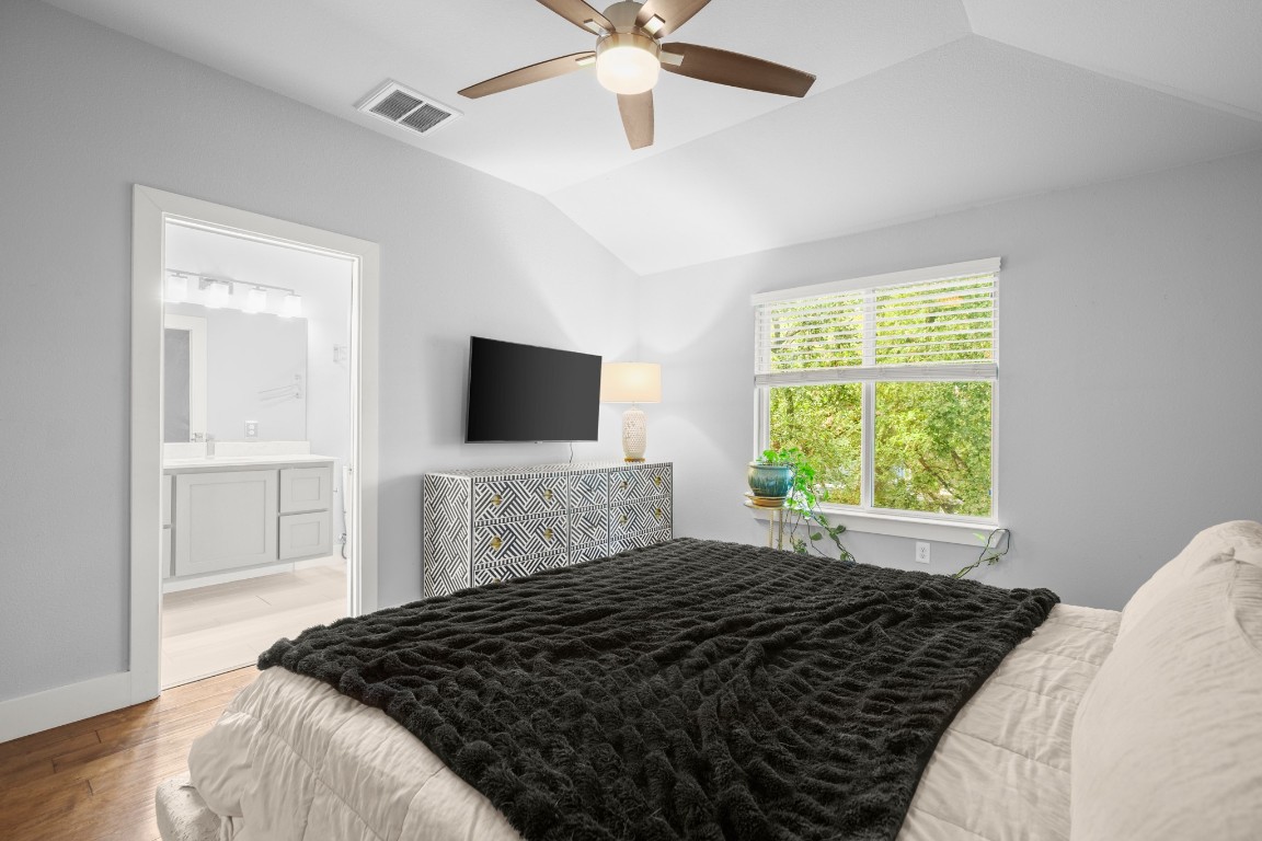 1220 Delano Street, Unit B Austin, TX 78721 - Photo 15 of 24 a bedroom with a bed window and a flat tv screen