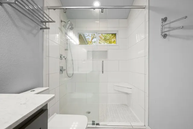 a bathroom with a shower a toilet and sink
