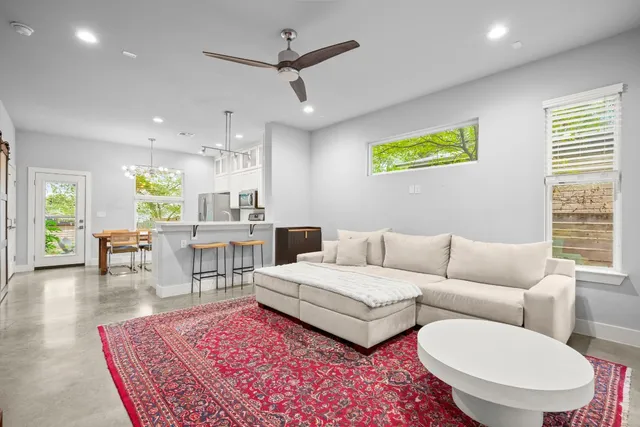 a living room with furniture a rug and a chandelier