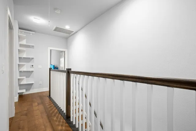 a view of a hallway with wooden floor and entryway
