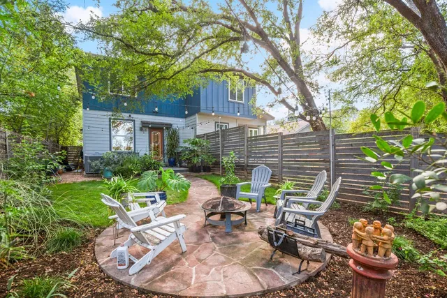 a view of a chair and table in backyard of the house