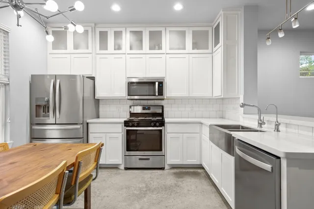 a kitchen with stainless steel appliances granite countertop a refrigerator stove and sink
