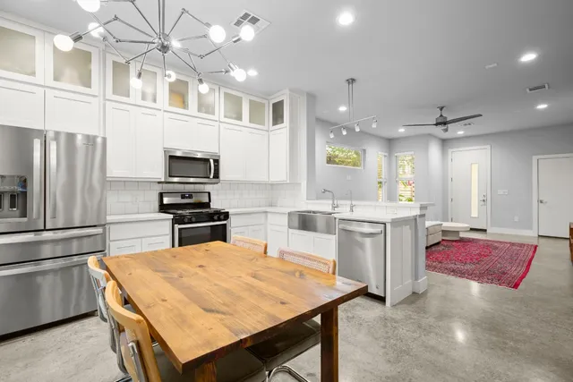 a kitchen with a refrigerator a stove top oven a sink dishwasher and white cabinets with wooden floor