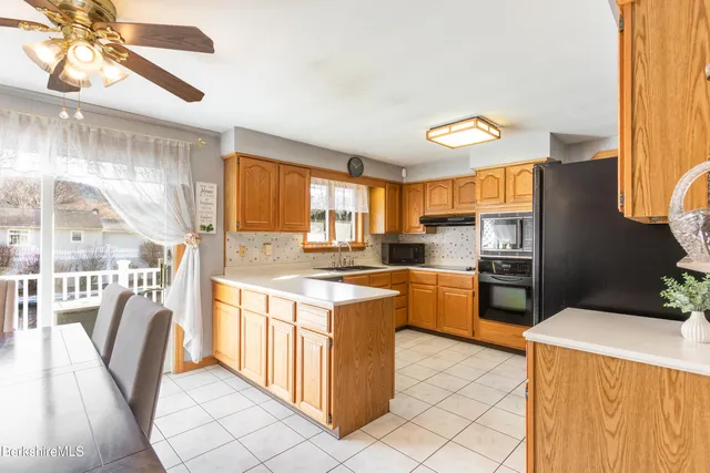 a kitchen with a stove a refrigerator and wooden floor