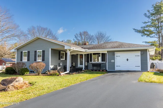 a front view of a house with swimming pool and porch