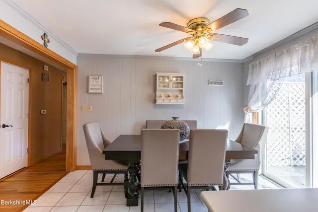 a view of a dining room with furniture and a chandelier fan