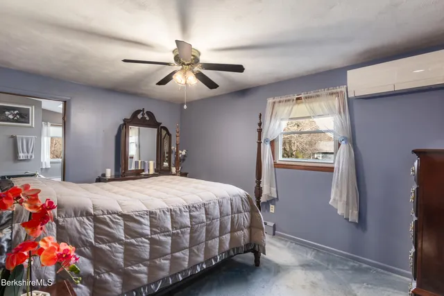 a bedroom with a bed chandelier and a window