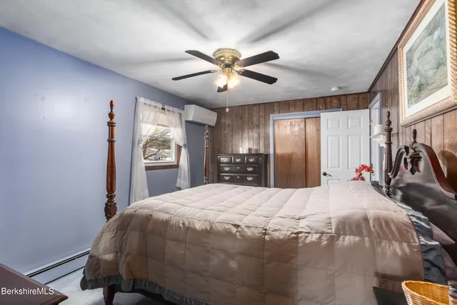 a bed sitting in a spacious bedroom next to a window