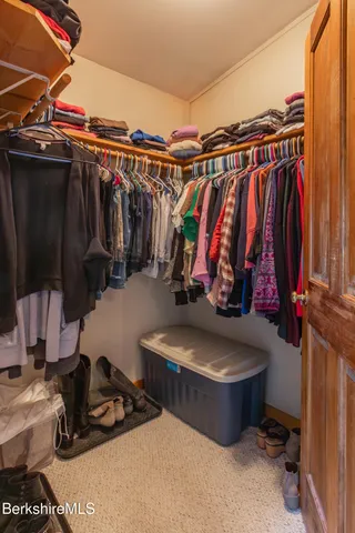 a view of walk in closet with clothes and shoes