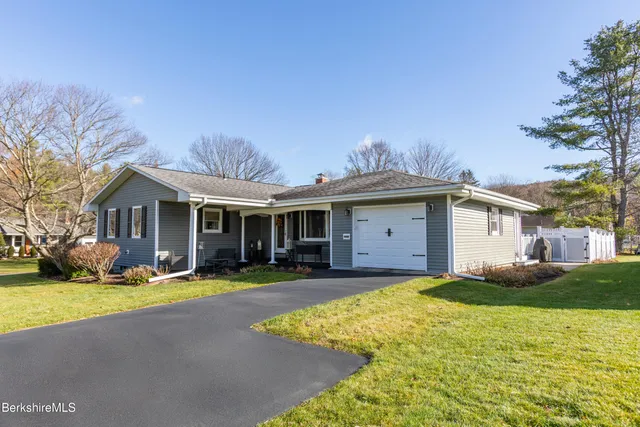 a view of a house with a yard and sitting area