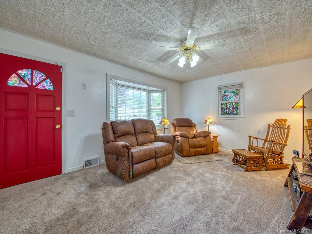 154 Camp Branch Road Waynesville, NC 28786 - Photo 16 of 29 a living room with furniture and a chandelier