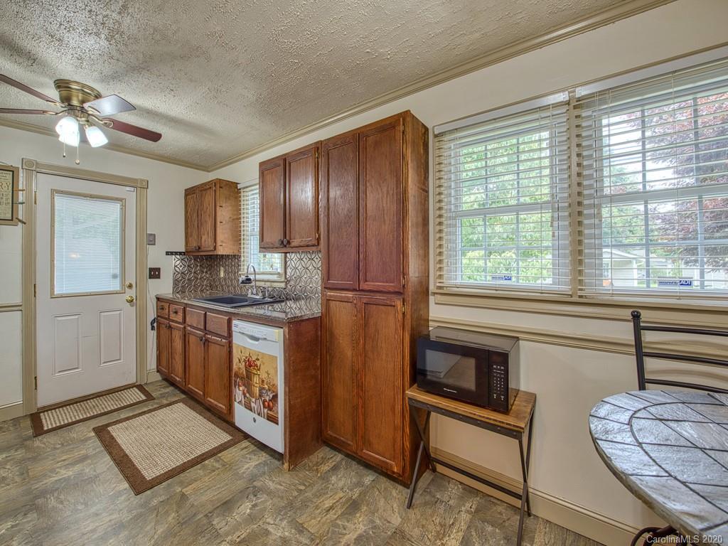 154 Camp Branch Road Waynesville, NC 28786 - Photo 20 of 29 a kitchen with granite countertop wooden cabinets a sink a window and stainless steel appliances