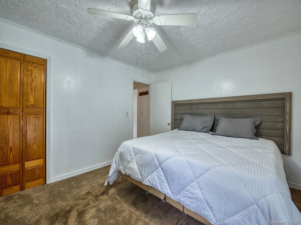 154 Camp Branch Road Waynesville, NC 28786 - Photo 25 of 29 a bedroom with a bed and a chandelier