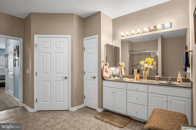a bathroom with a double vanity sink a mirror and a shower