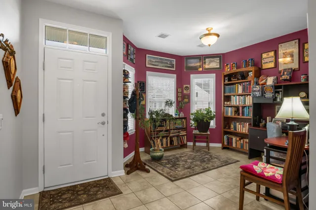 a living room with furniture a bookshelf and a window