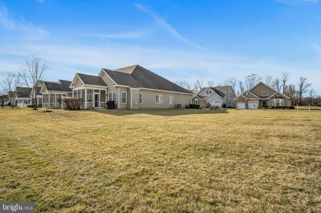 a view of a house with a big yard and large trees