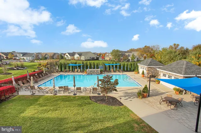 a view of a swimming pool with lawn chairs and a fire pit