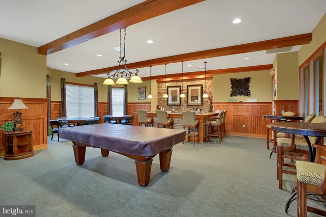 a dining hall with couches a table and chairs with wooden floor