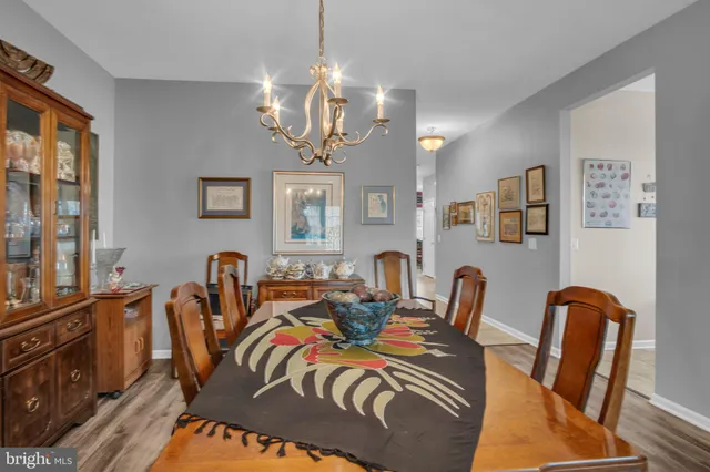 a view of a dining room with furniture a chandelier and window