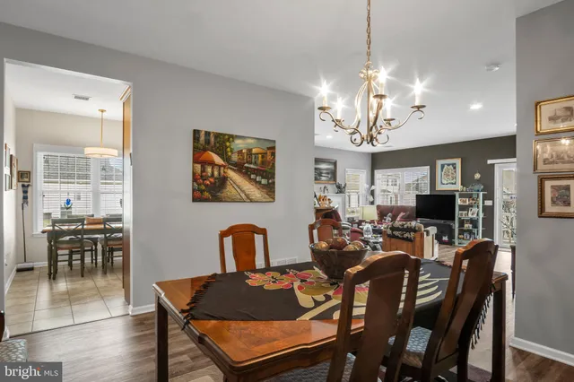 a view of a dining room with furniture a chandelier and wooden floor