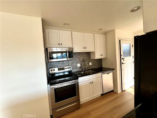 a kitchen with granite countertop a refrigerator and a sink