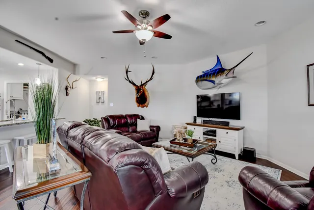 a living room with furniture a ceiling fan and a rug