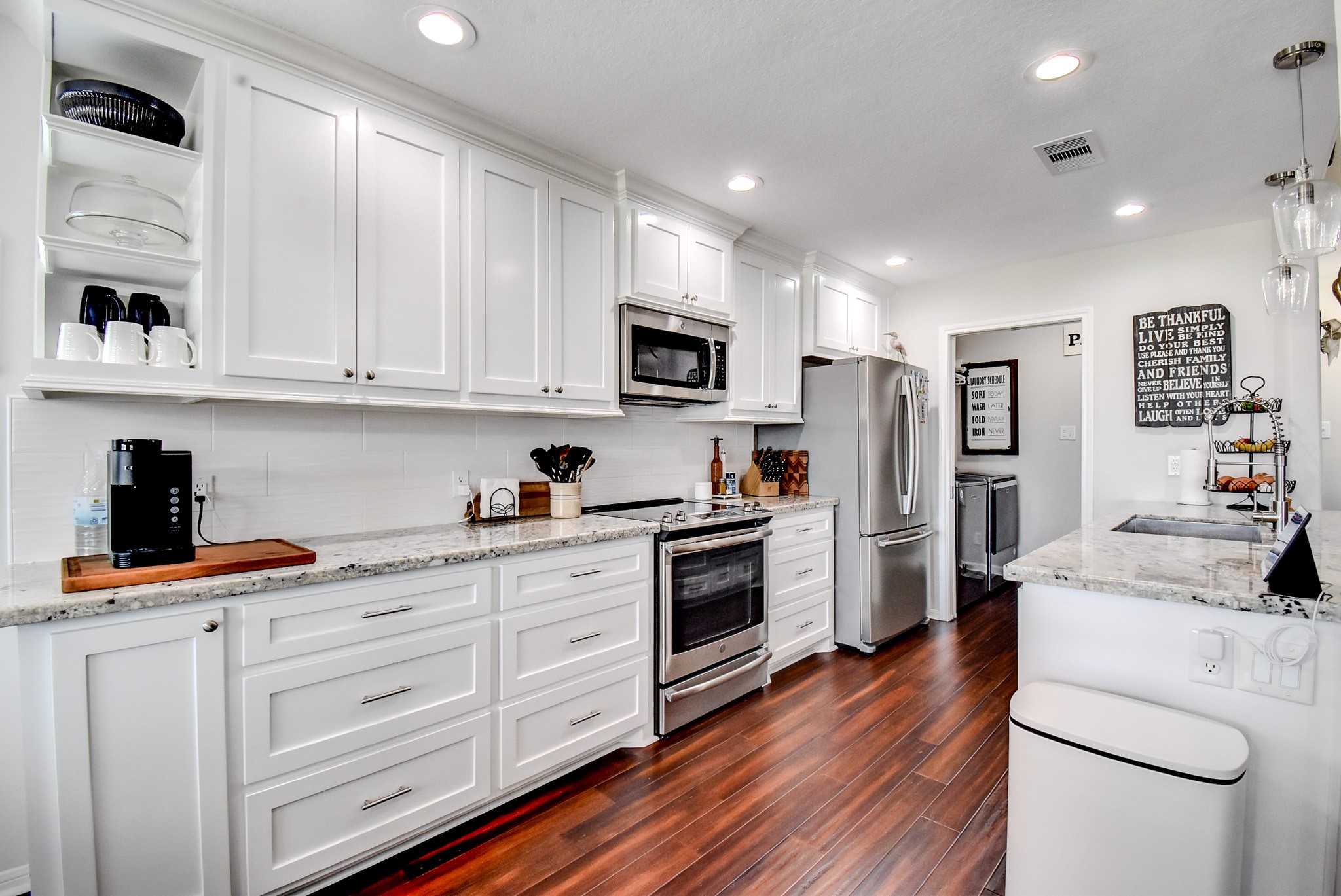 122 Four Master Road Freeport, TX 77541 - Photo 17 of 50 a kitchen with white cabinets and stainless steel appliances