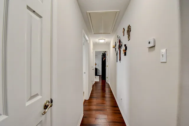 a view of a hallway with wooden floor and staircase