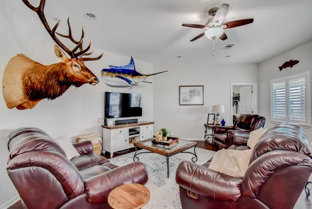 a living room with furniture a flat screen tv and a window