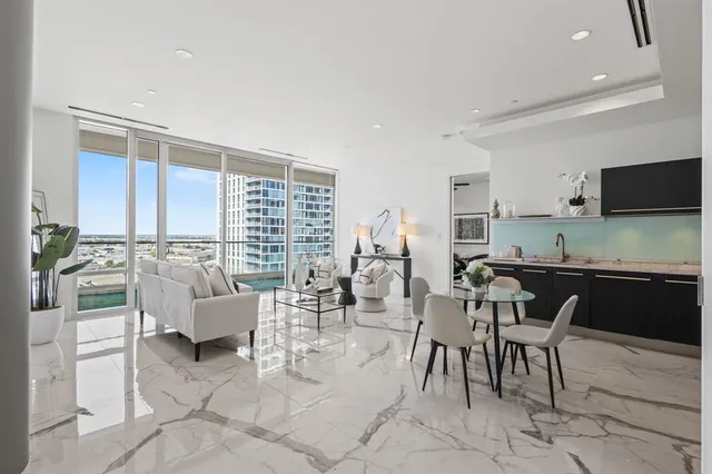 a living room with furniture a flat screen tv and a large window