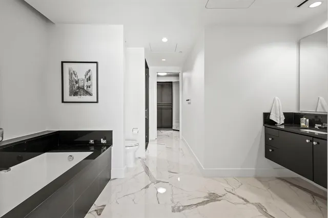 a kitchen with granite countertop a stove a sink and a refrigerator