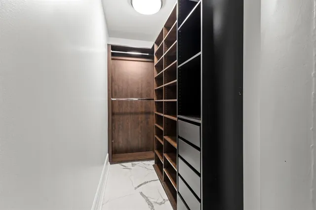 a view of walk in closet with empty racks